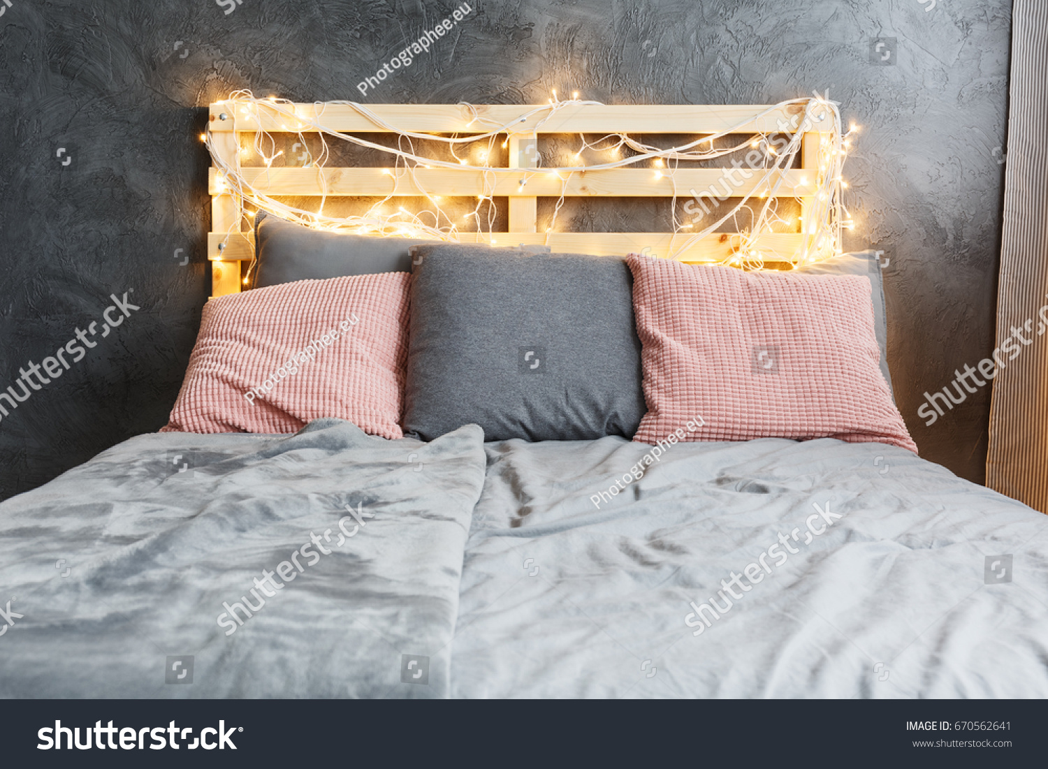 Cozy dreamy bed with decorated DIY pallet headboard #670562641