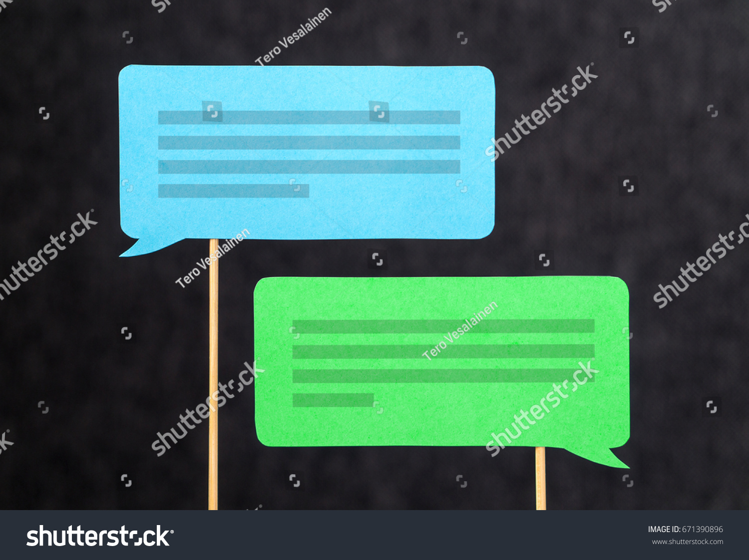 2 chat bubbles and speech balloons having discussion. Modern communication and conversation concept. Mobile and smartphone communication design made from cardboard and wooden stick. #671390896
