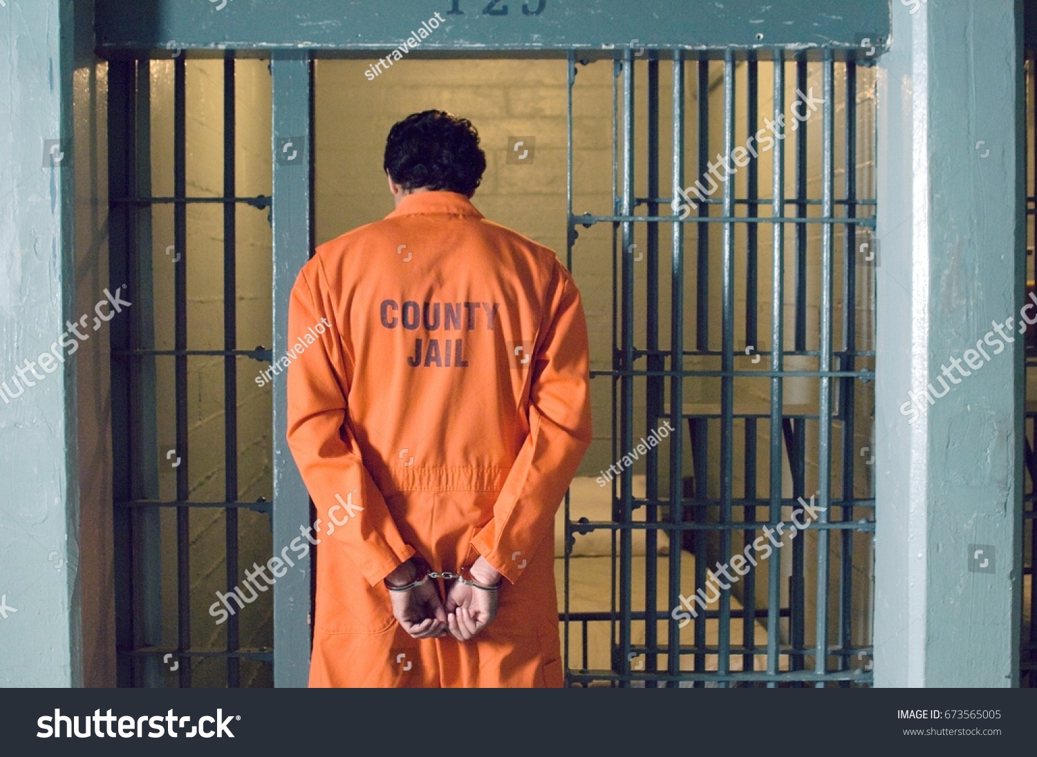 Handcuffed prisoner in jail #673565005