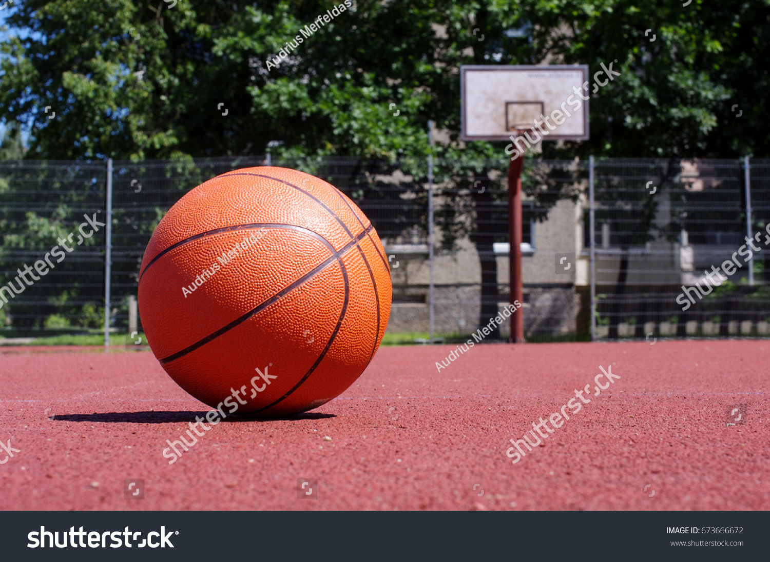 Basketball ball in the outdoors court sunny day #673666672