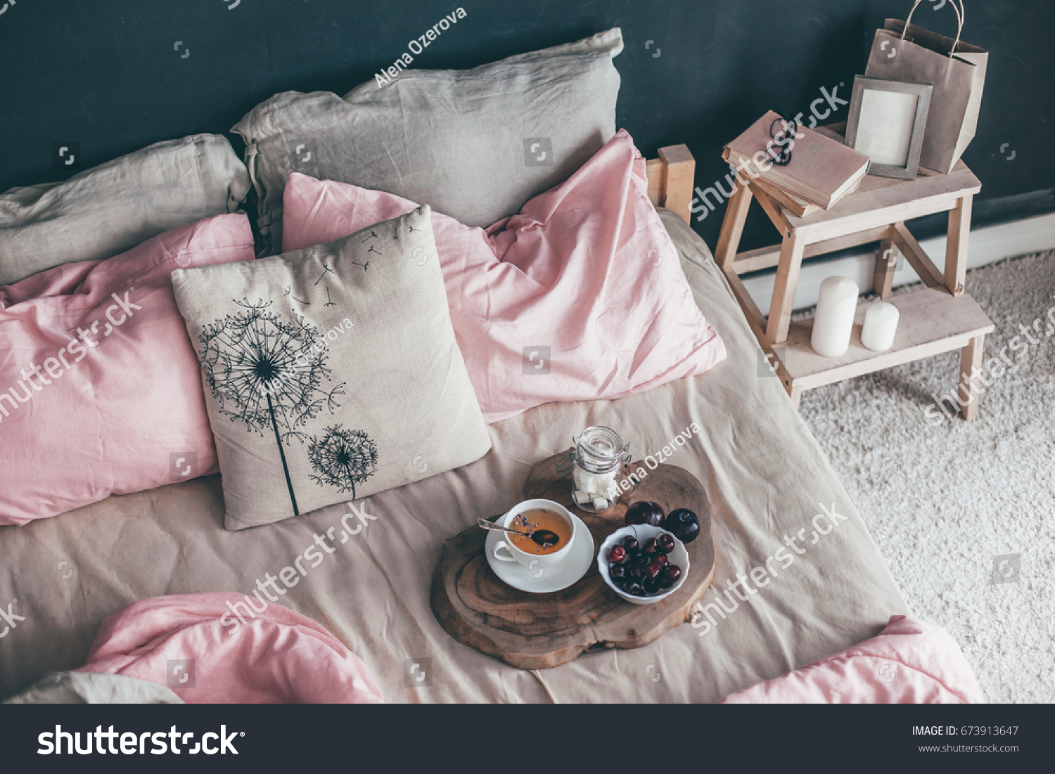 Black loft bedroom and pastel bedding set. Unmade bed with breakfast and reading on tray. Interior decor over blackboard wall. Cozy modern living space. #673913647