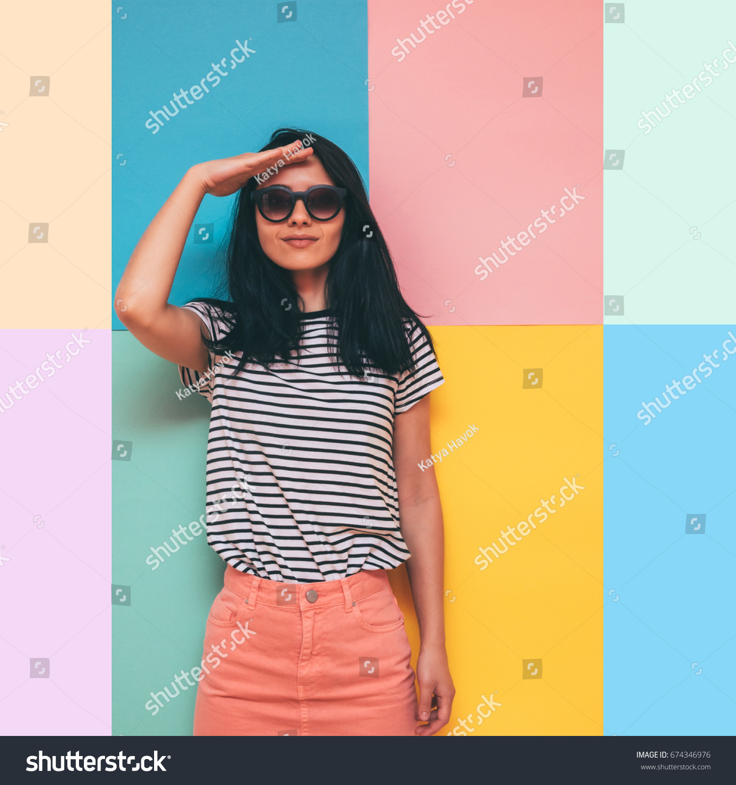 the woman salutes. fashionable pink denim skirt, and trendy stripes on the shirt. #674346976