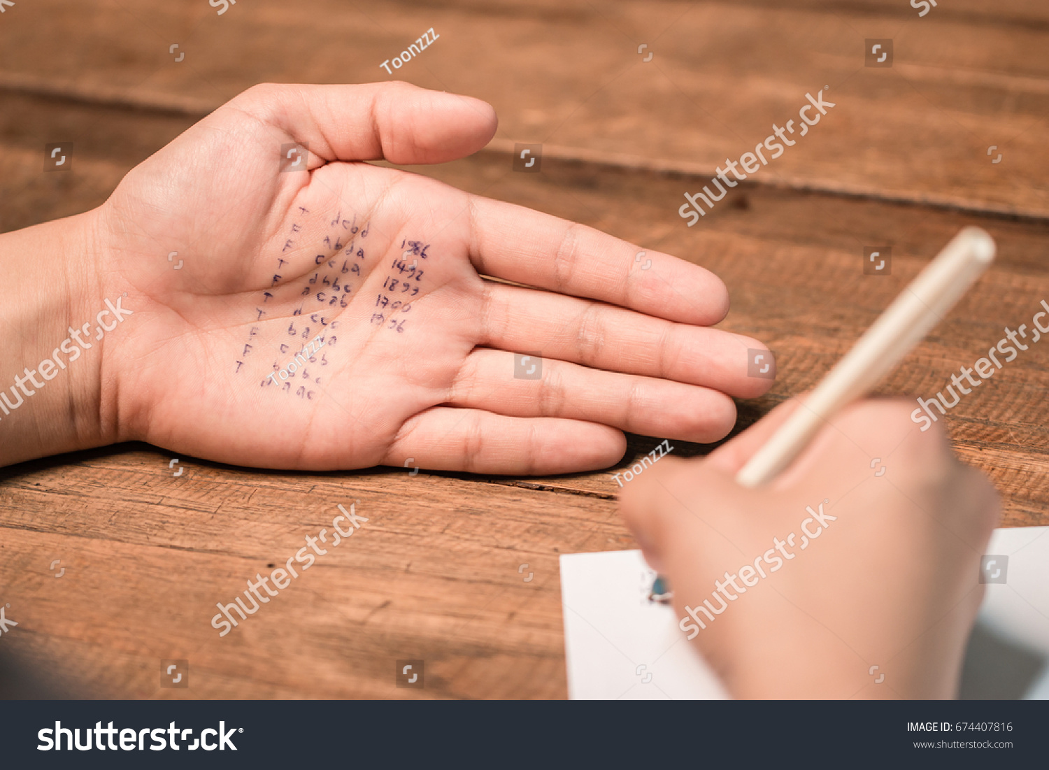 People cheating on test by writing answer on hand #674407816