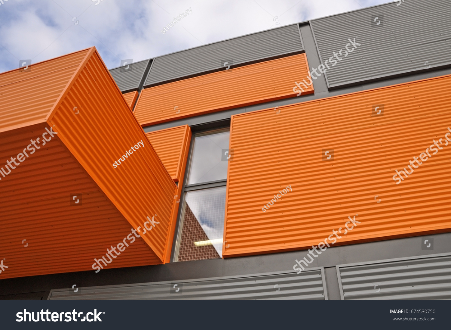 Architectural background. Wall of the modern orange and black corrugated metal panels. Look up. #674530750