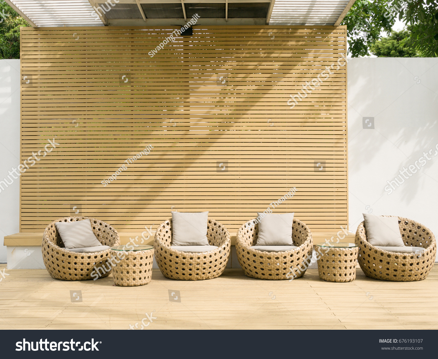 Outdoor relaxing space with trees around and rattan furniture #676193107