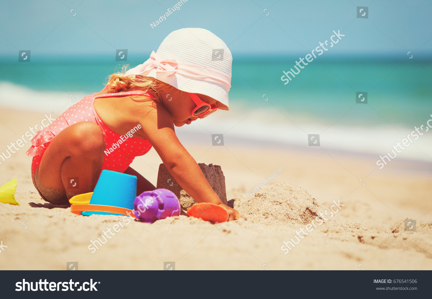 cute little girl play with sand on beach #676541506