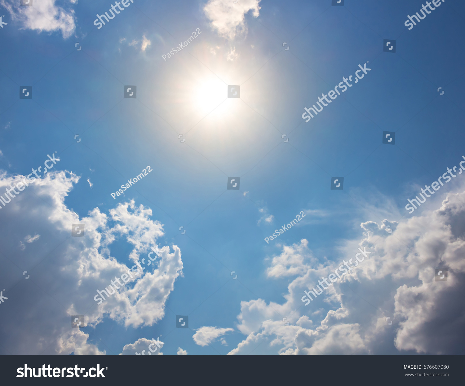 Sun with orange light on blue sky and bright clouds #676607080