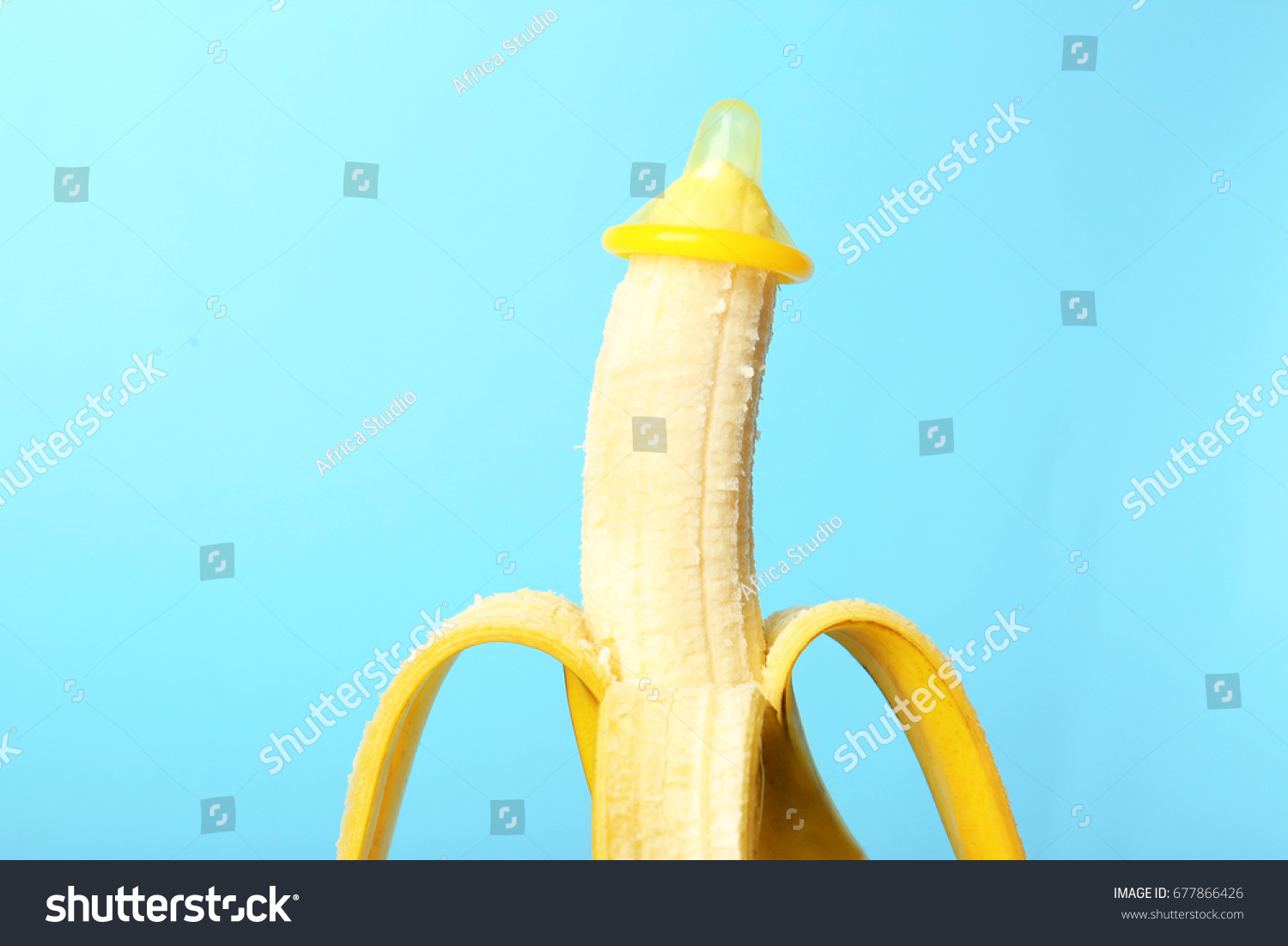 Condom on banana against color background. Safe sex concept #677866426