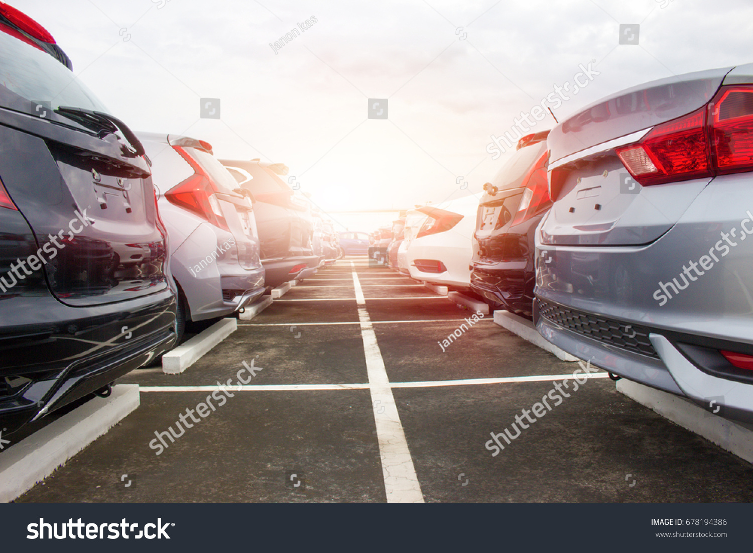 A row of new cars parked at a car dealership stock #678194386