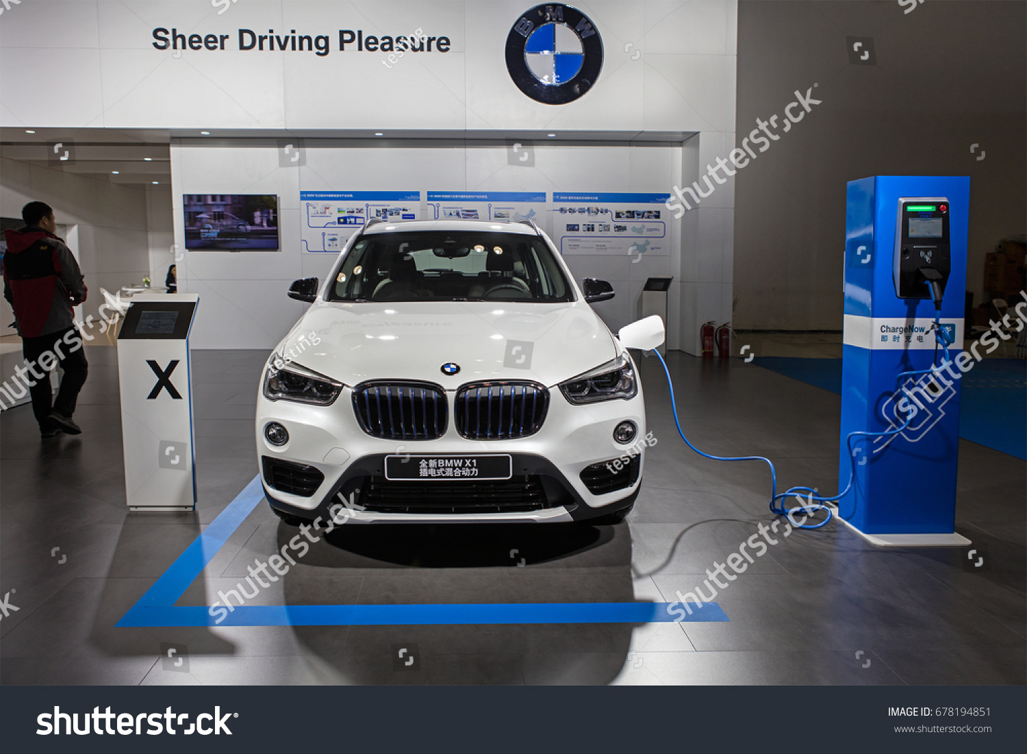 BEIJING, CHINA - OCTOBER 15, 2016: BMW X1 electric vehicle is connected to a electric charging station at the China International New Energy Automobile Exhibition at China National Convention Center #678194851