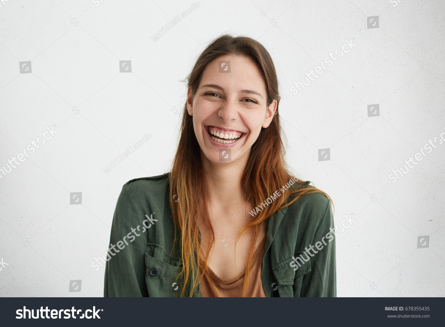 Good-looking female with sincere smile rejoicing her success at work having good mood showing her positive emotions. Woman with gentle smile. People, happiness, facial expressions and emotions #678355435