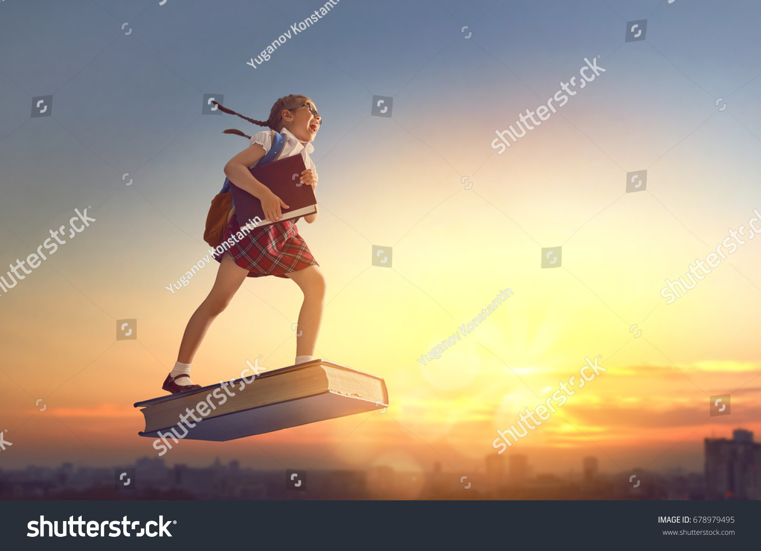 Back to school! Happy cute industrious child flying on the book on background of sunset urban landscape. Concept of education and reading. The development of the imagination. #678979495