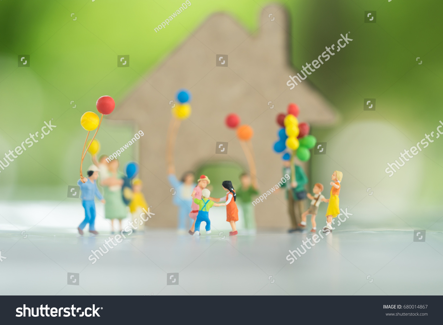Miniature people, family and children with colorful ballons  standing in front of house. International Day of Families #680014867