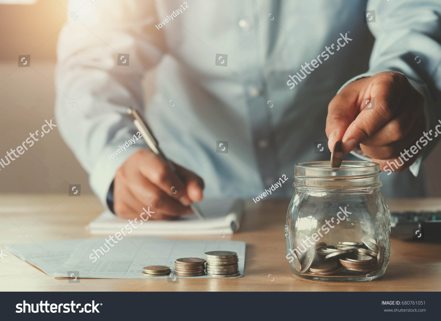 business accounting with saving money with hand putting coins in jug glass concept financial #680761051