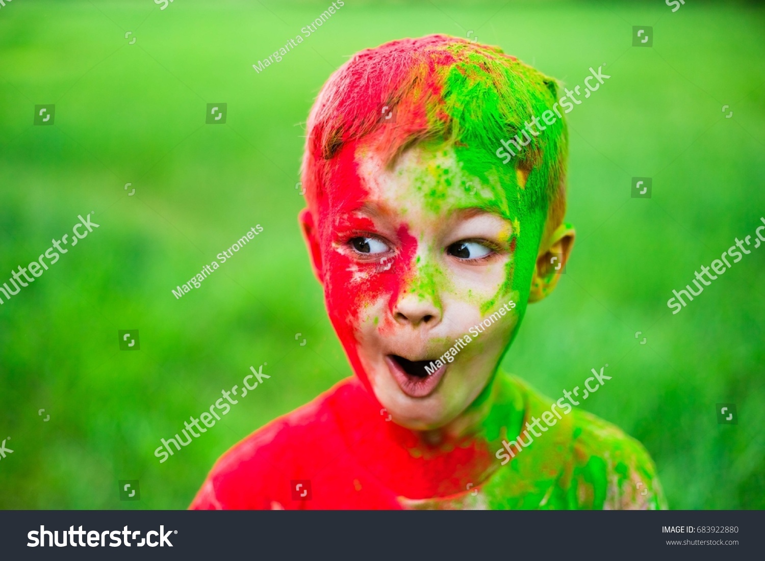 The boy smeared with paints of holi. Surprised by what is happening. Vivid, emotions, surprises and admiration #683922880