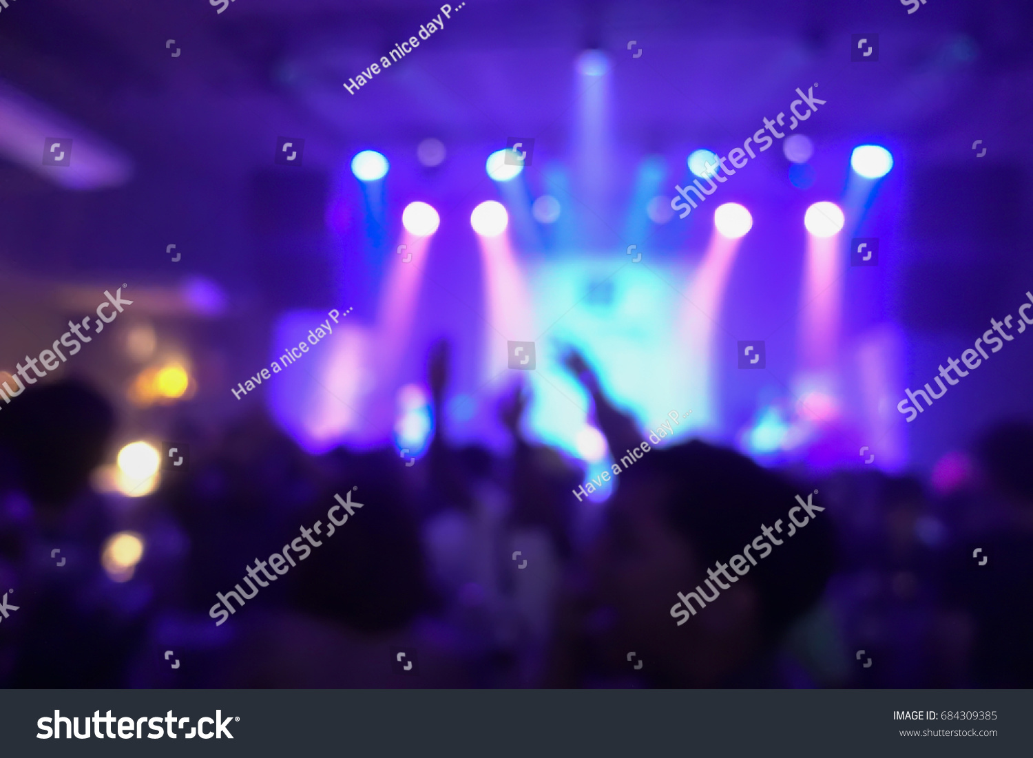Blur background of concert crowd in front of bright stage lights musics #684309385