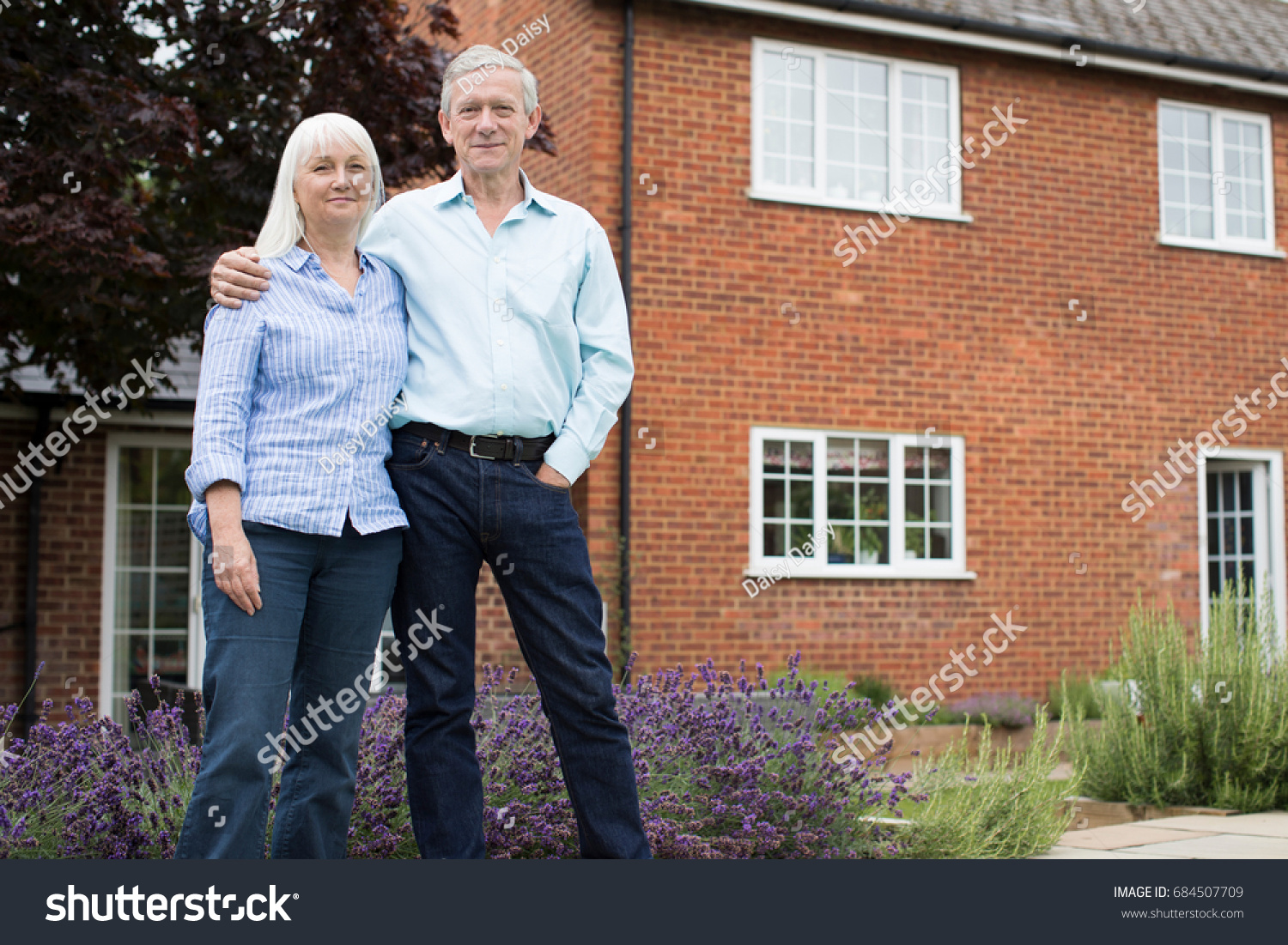 Portrait Of Retired Couple Standing Outside Home #684507709