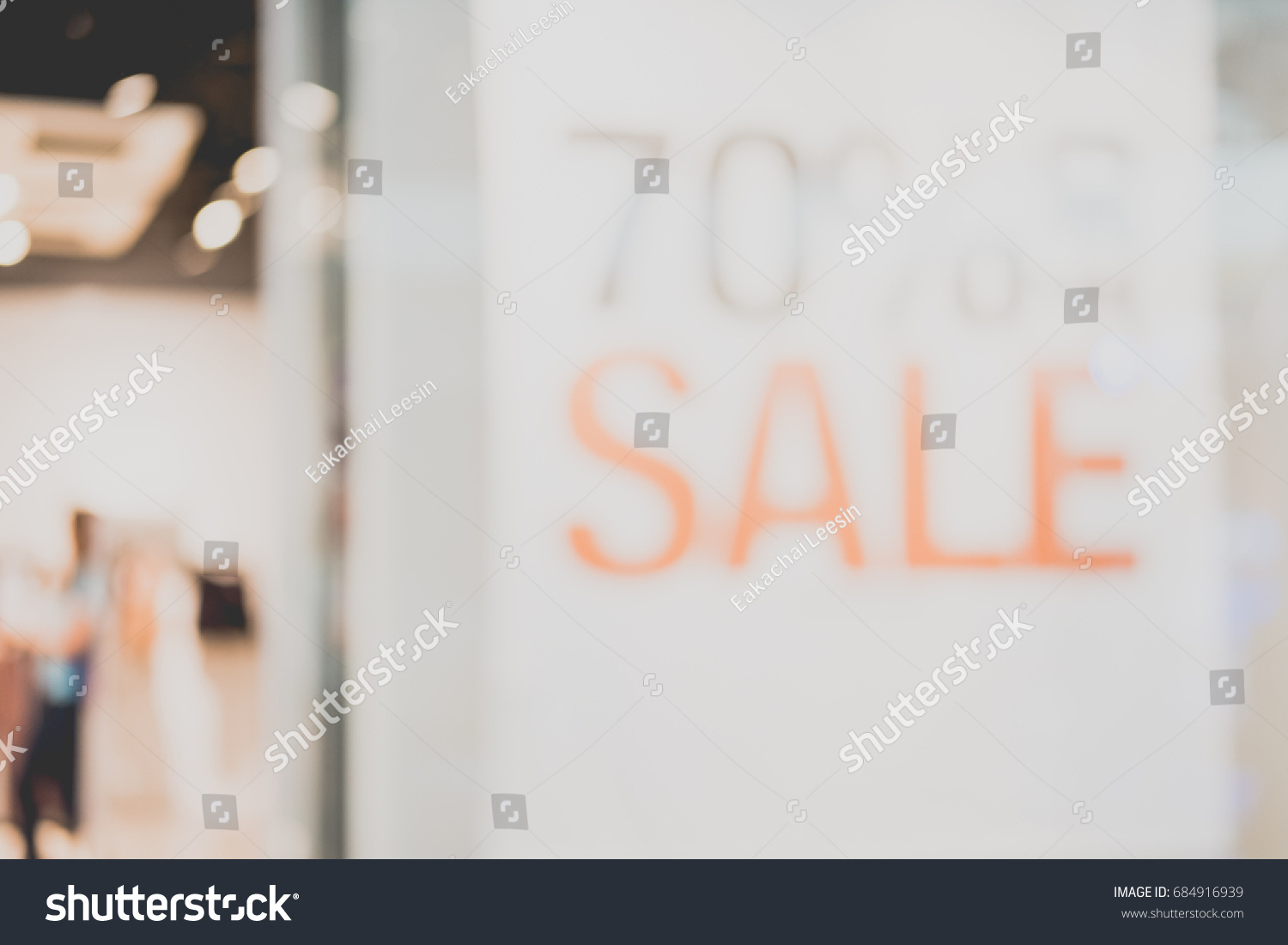 Shopping center with customers and seasonal sale promotions. Blurred, people unrecognizable #684916939