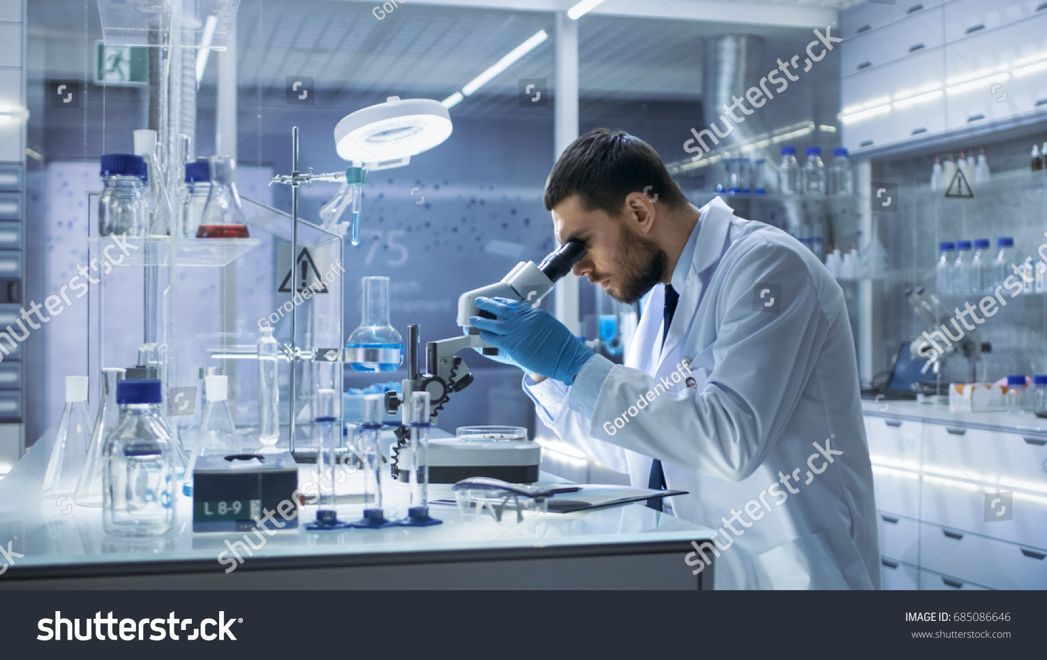 Research Scientist Looks into Microscope. He's Conducts Experiments in Modern Laboratory. #685086646