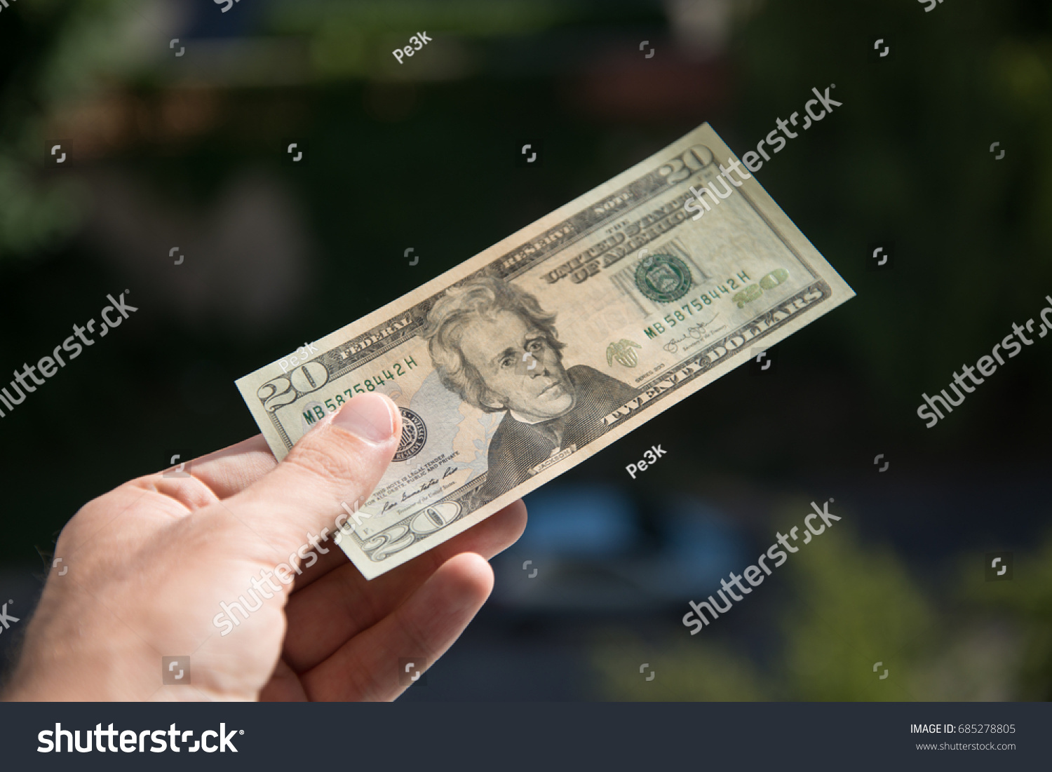 Man holding and giving 20 dollar banknote #685278805