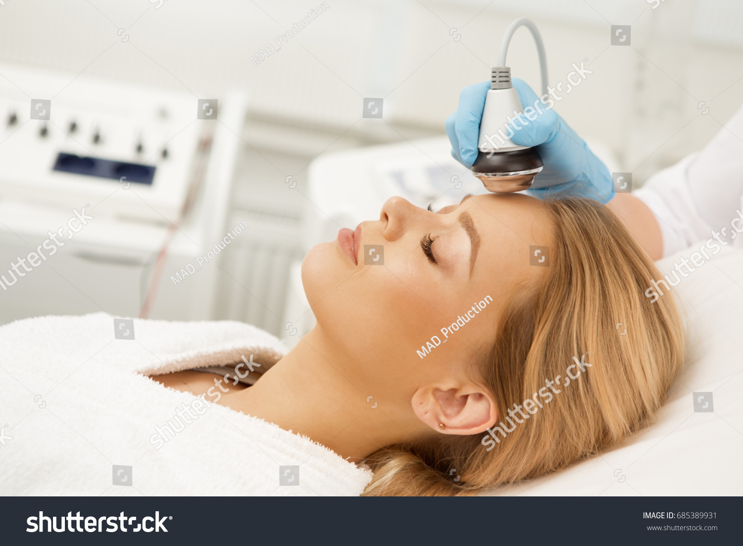 Gorgeous young woman lying with her eyes closed relaxing while receiving facial ultrasonic treatment at modern beauty spa clinic salon therapist therapy pampering skin refreshing procedure cosmetology #685389931