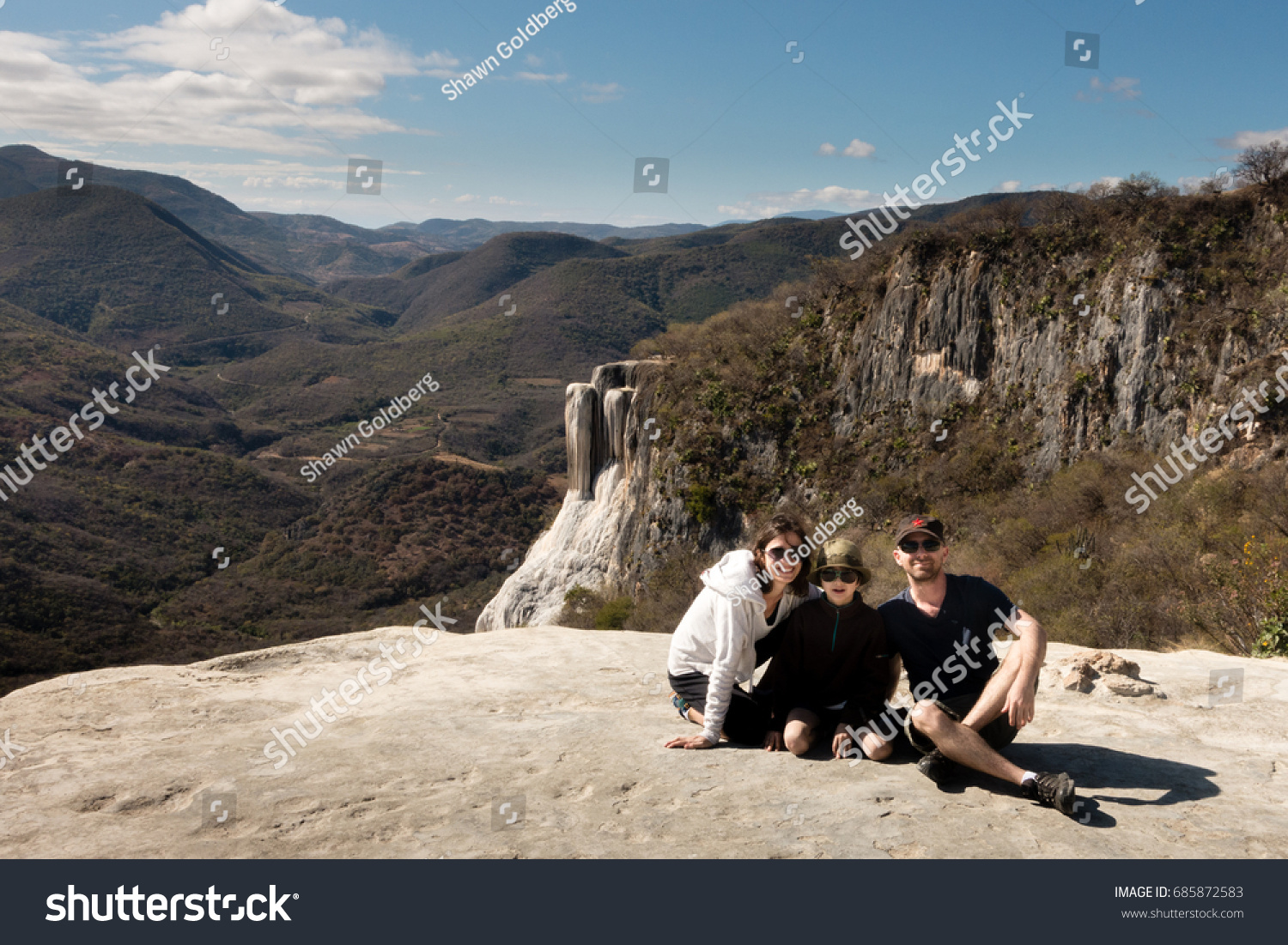 HIERVE EL AGUA, OAXACA, MEXICO - JANUARY 25, 2015: MOTHER, SON AND FATHER POSE FOR PHOTO AT Hierve el Agua, a set of natural rock formations that resemble cascades of water.  #685872583
