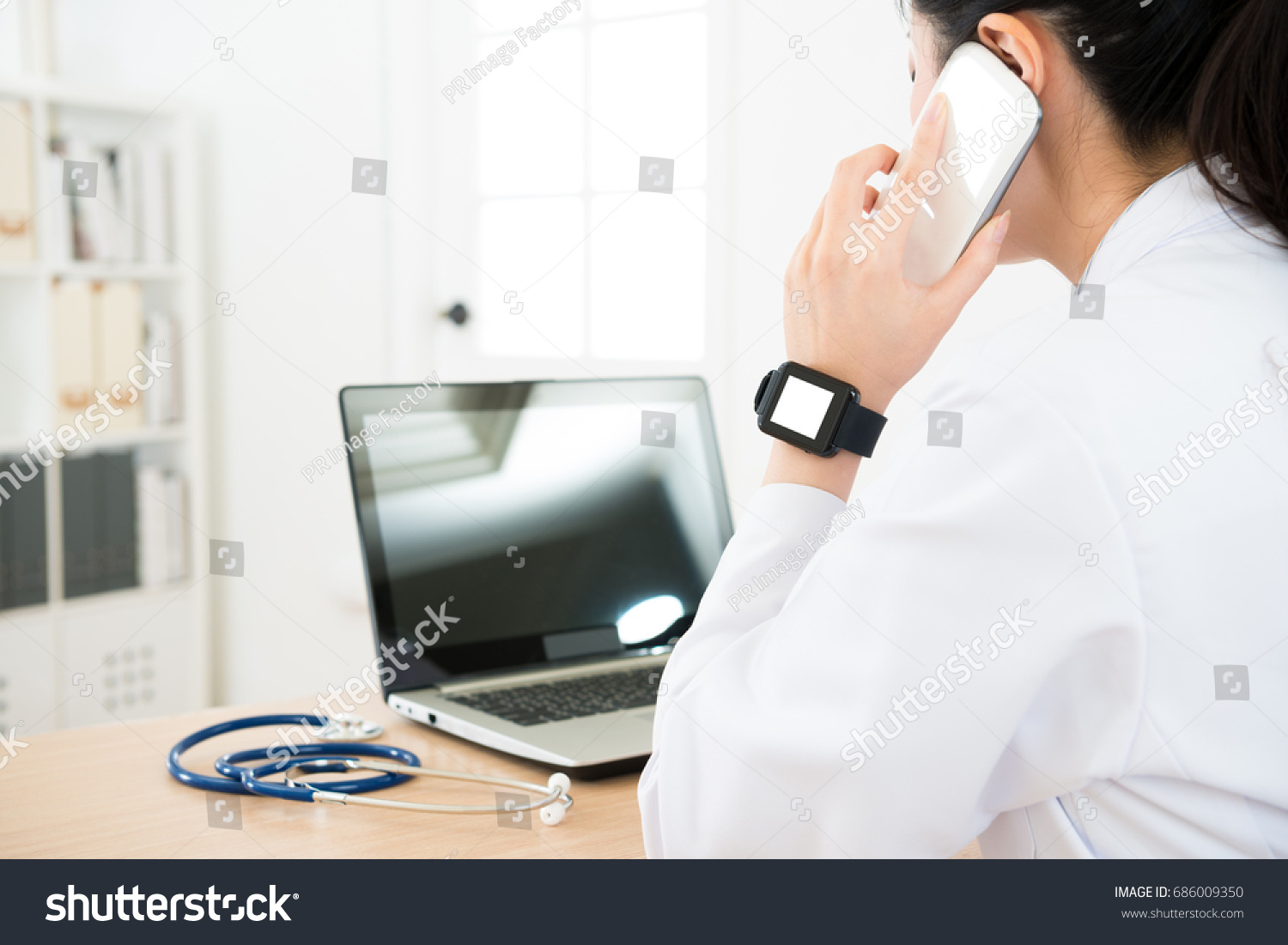 elegant beauty doctor woman wearing blank screen smartwatch working and using mobile phone talking with patient to solve sick problem. #686009350