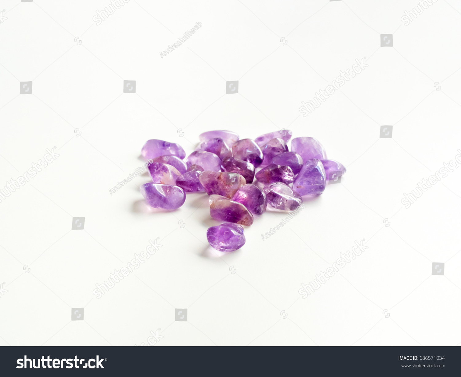 Tumbled Amethyst stones close up on table for crystal therapy treatments and reiki #686571034