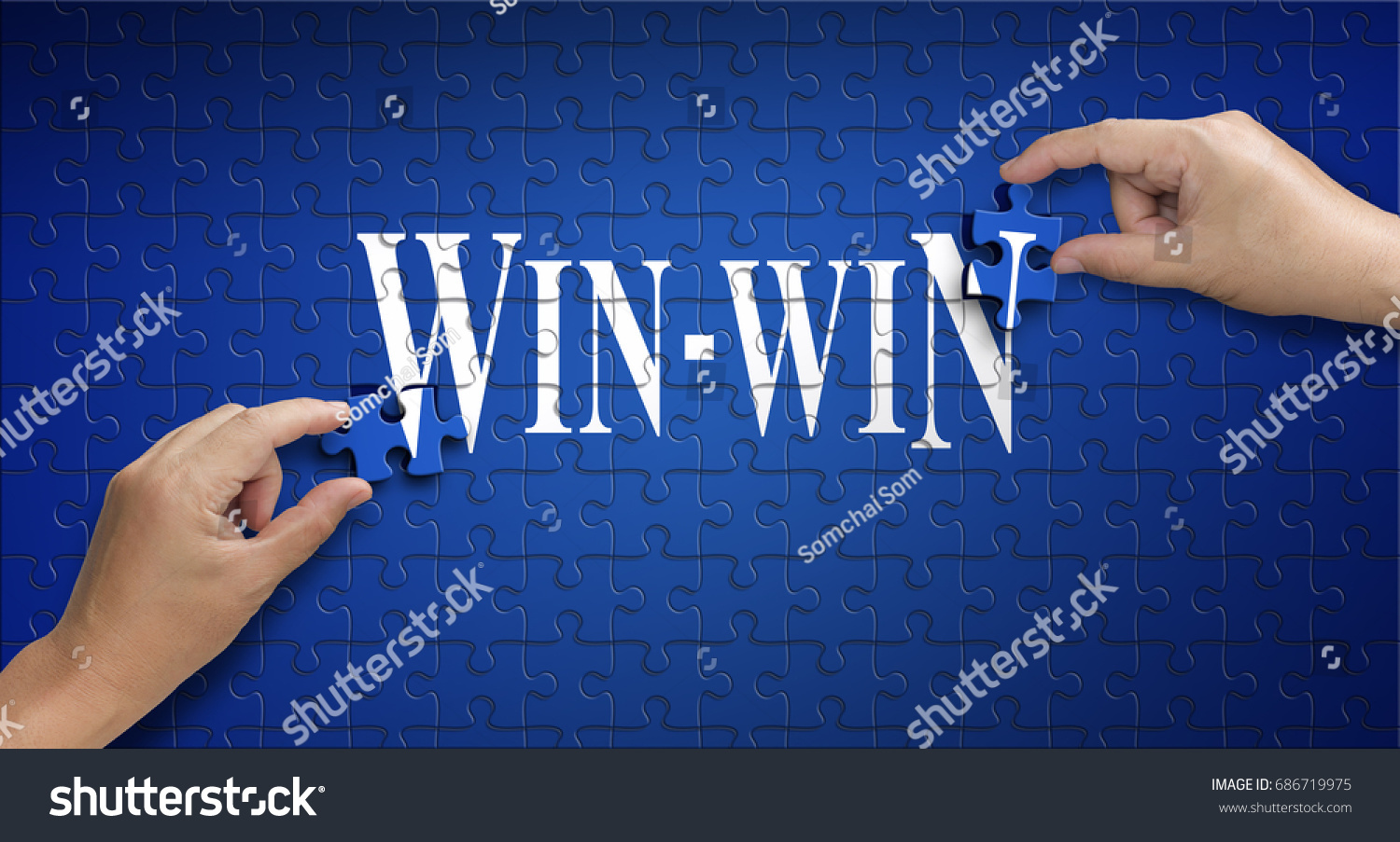 win win word on Jigsaw puzzle - business concept. Man hand holding a blue puzzle to complete the word win-win divided over them concept of the solution to a problem, challenge, plan and strategy. #686719975