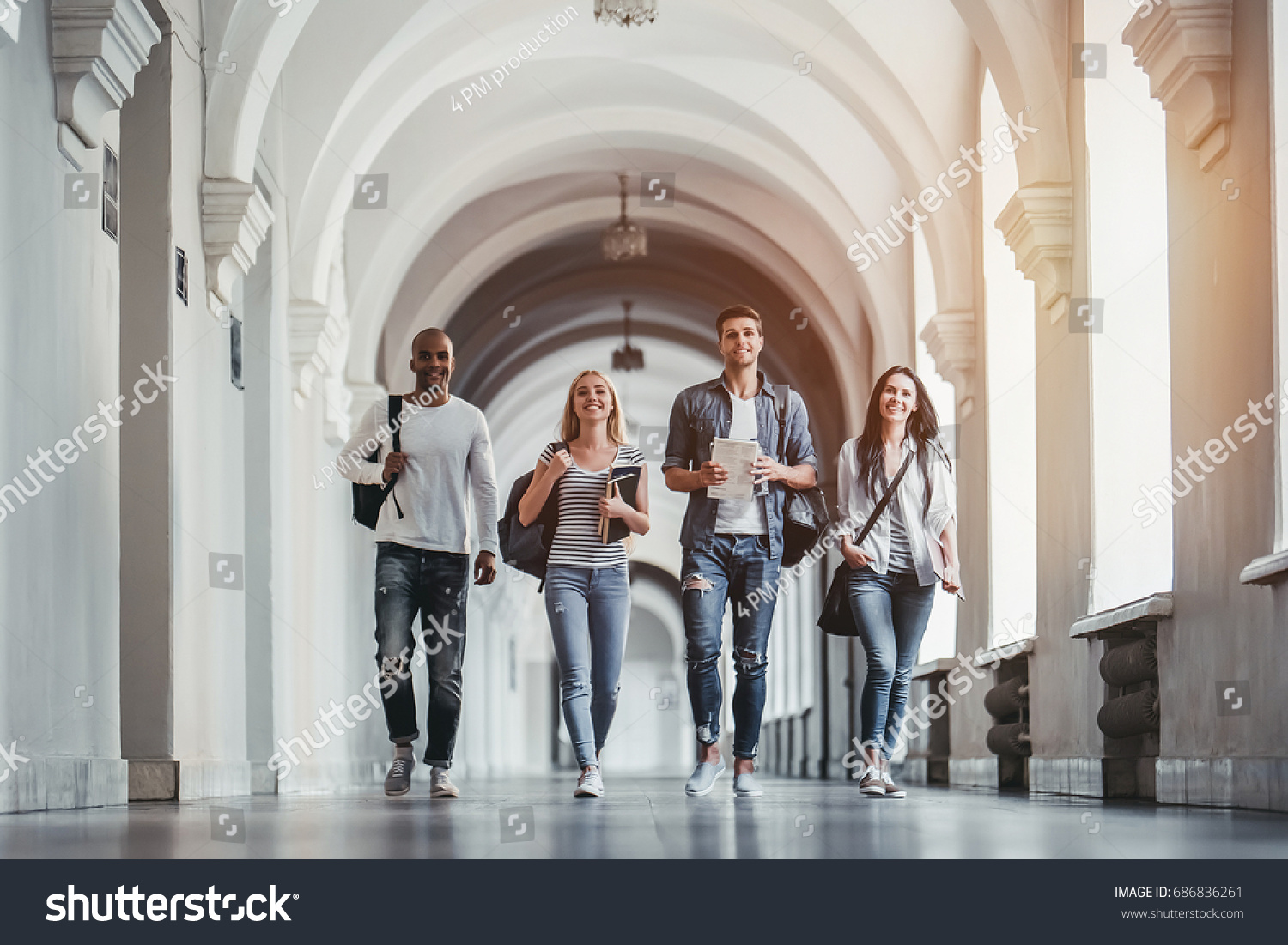 Multiracial students are walking in university hall during break. #686836261