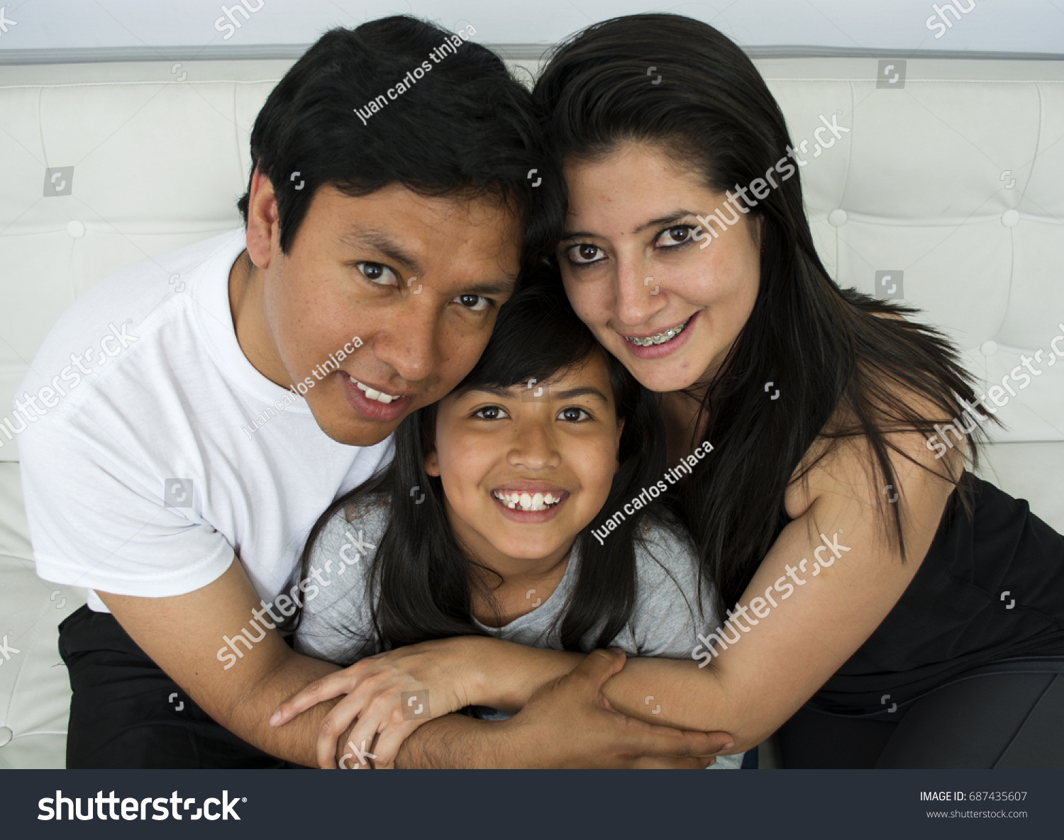 Happy young family sitting on sofa. #687435607