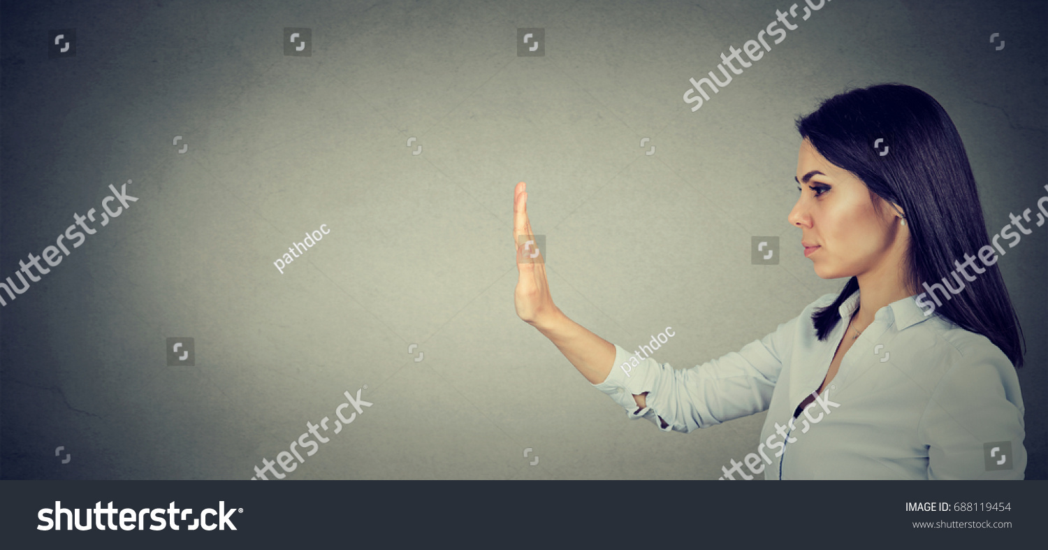 Side profile of young woman with stop hand gesture  #688119454