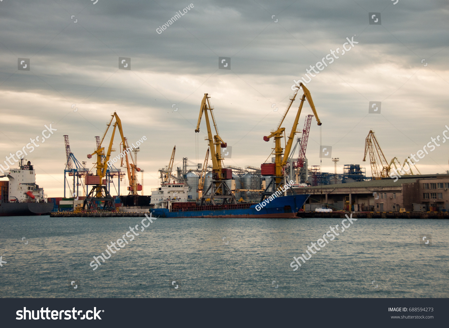 Bulk cargo ship under port crane bridge, Odessa, Ukraine. Odessa Marine Trade Port. Large container vessel. Industrial container freight. Shipping port. Industrial background. #688594273
