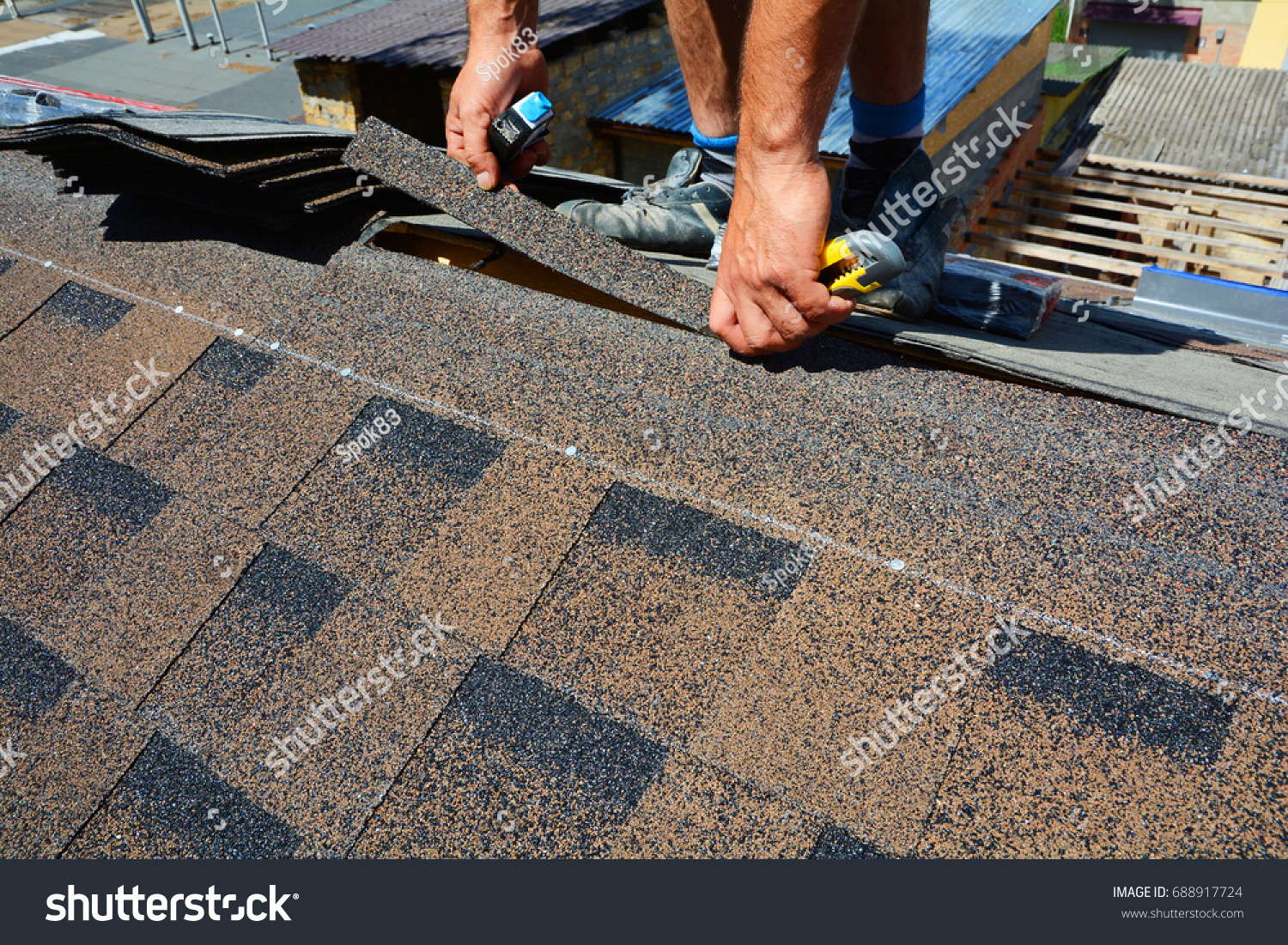 Repairing of roof by cutting felt or bitumen shingles during waterproofing works. #688917724