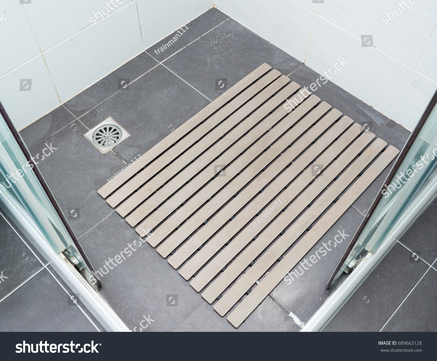 Rubber slip pad with the many hair pieces in the shower stall of the modern house. #689663128