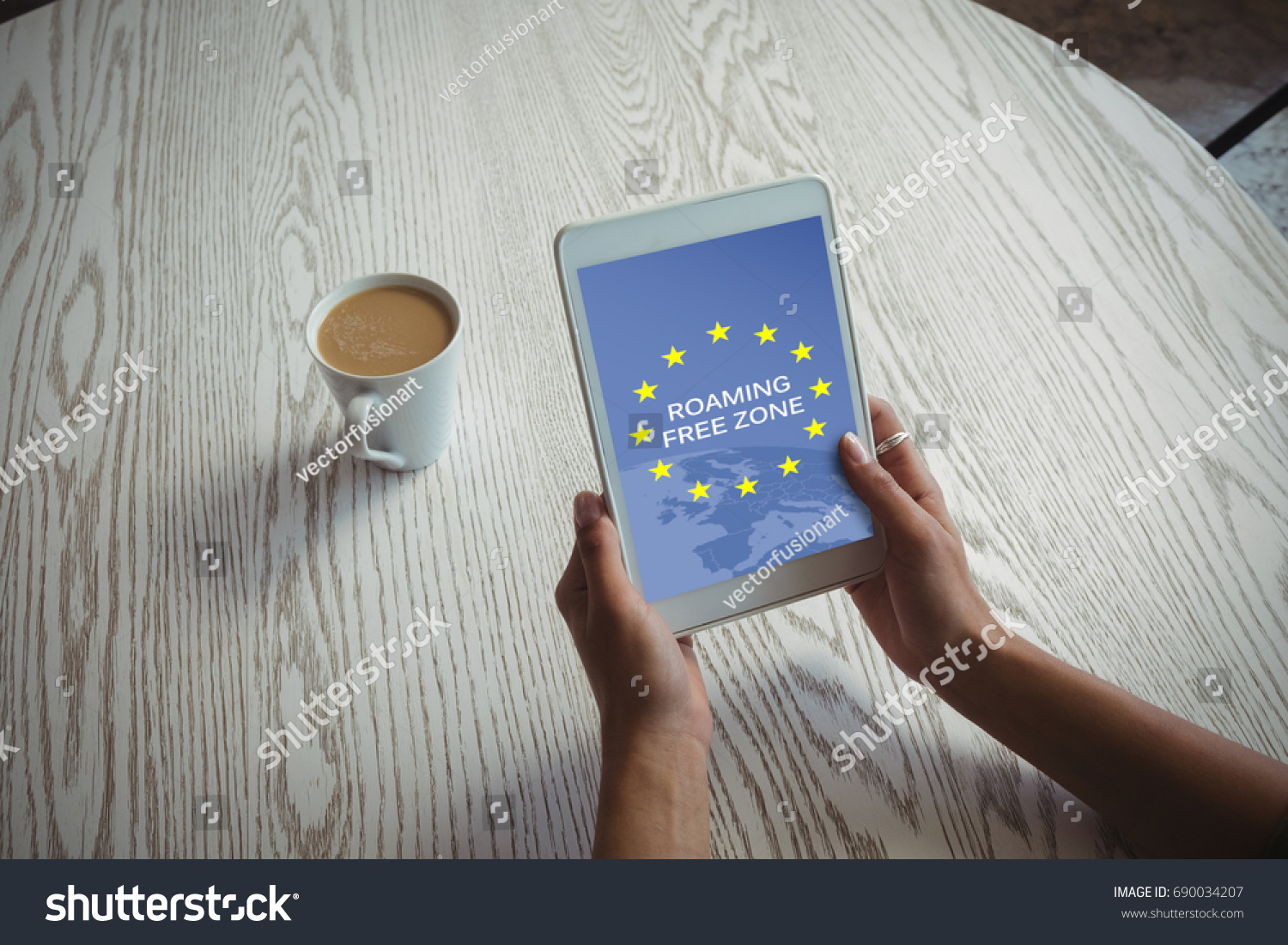 Roaming free zone text on European Union flag against cropped image of woman holding tablet #690034207