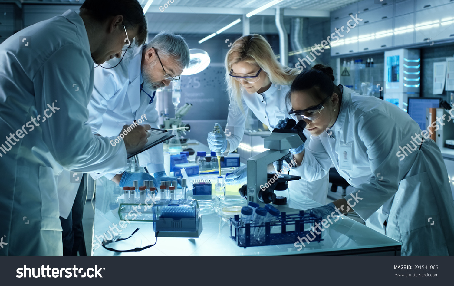 Team of Medical Research Scientists Collectively Working on a New Generation Experimental Drug Treatment. Laboratory Looks Busy, Bright and Modern. #691541065