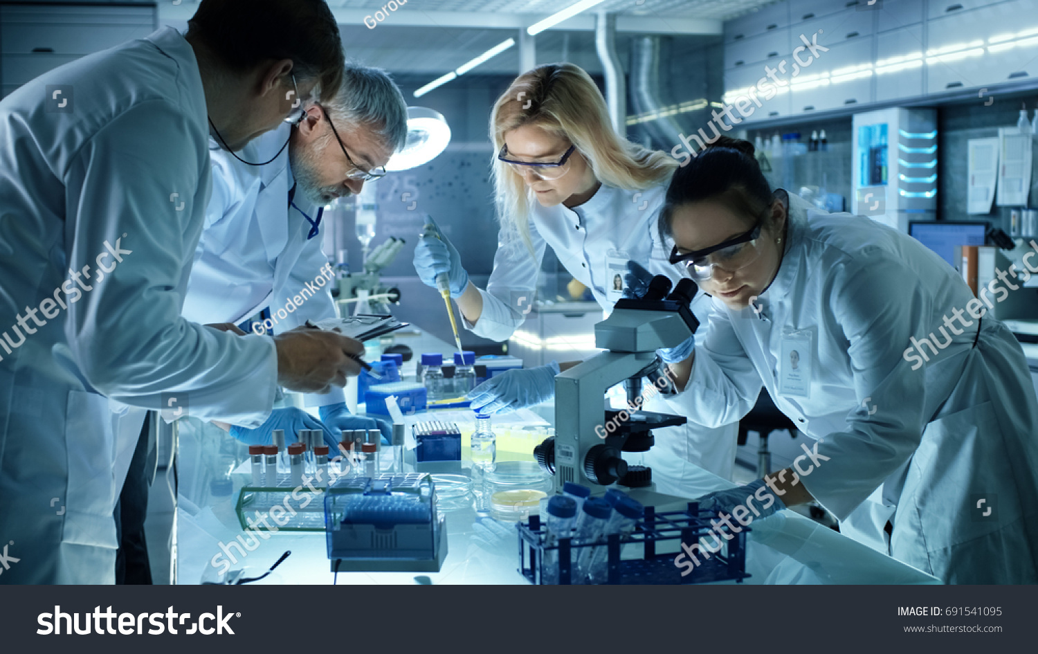 Team of Medical Research Scientists Collectively Working on a New Generation Experimental Drug Treatment. Laboratory Looks Busy, Bright and Modern. #691541095