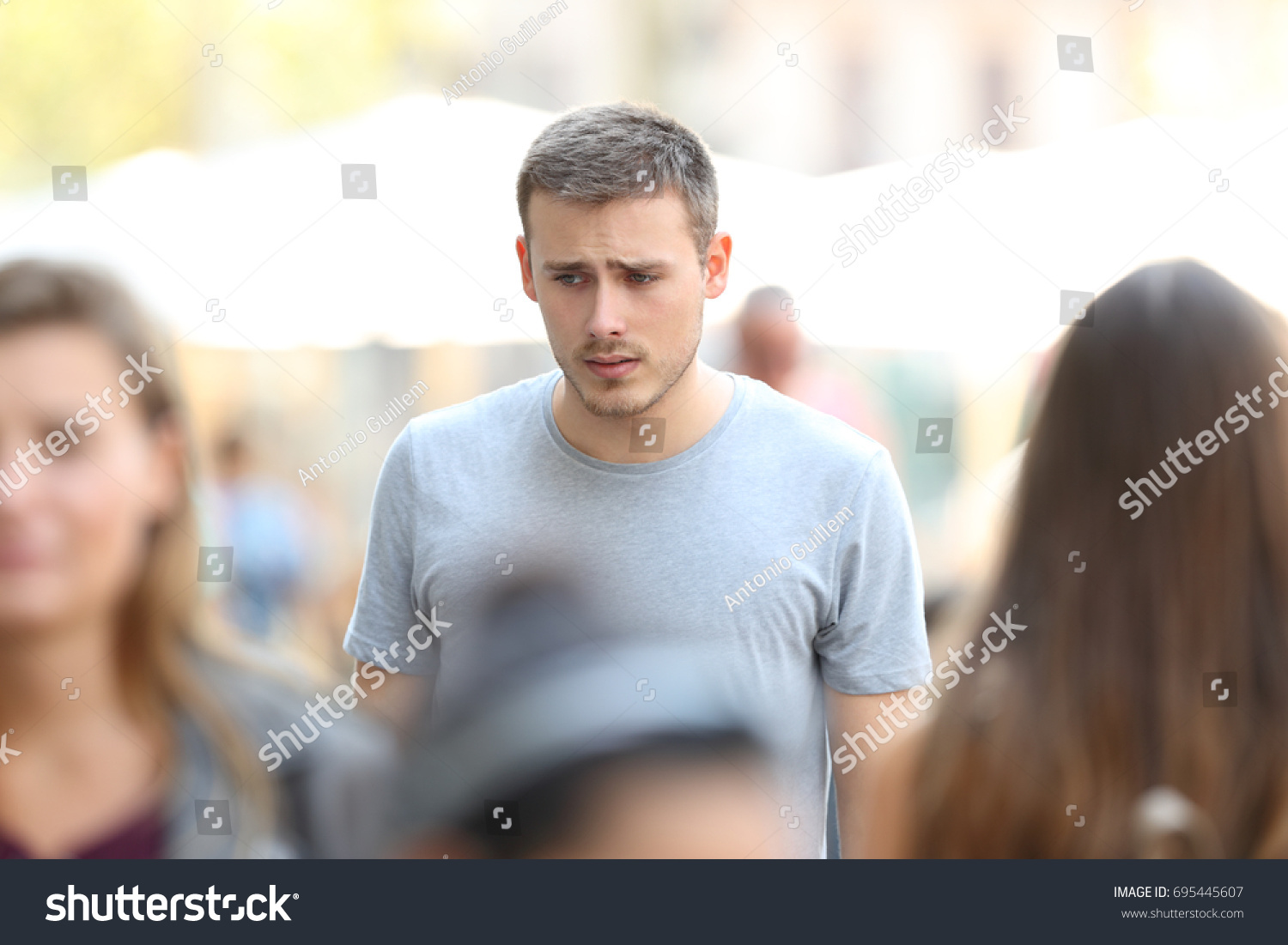 Front view portrait of a sad boy walking on the street #695445607