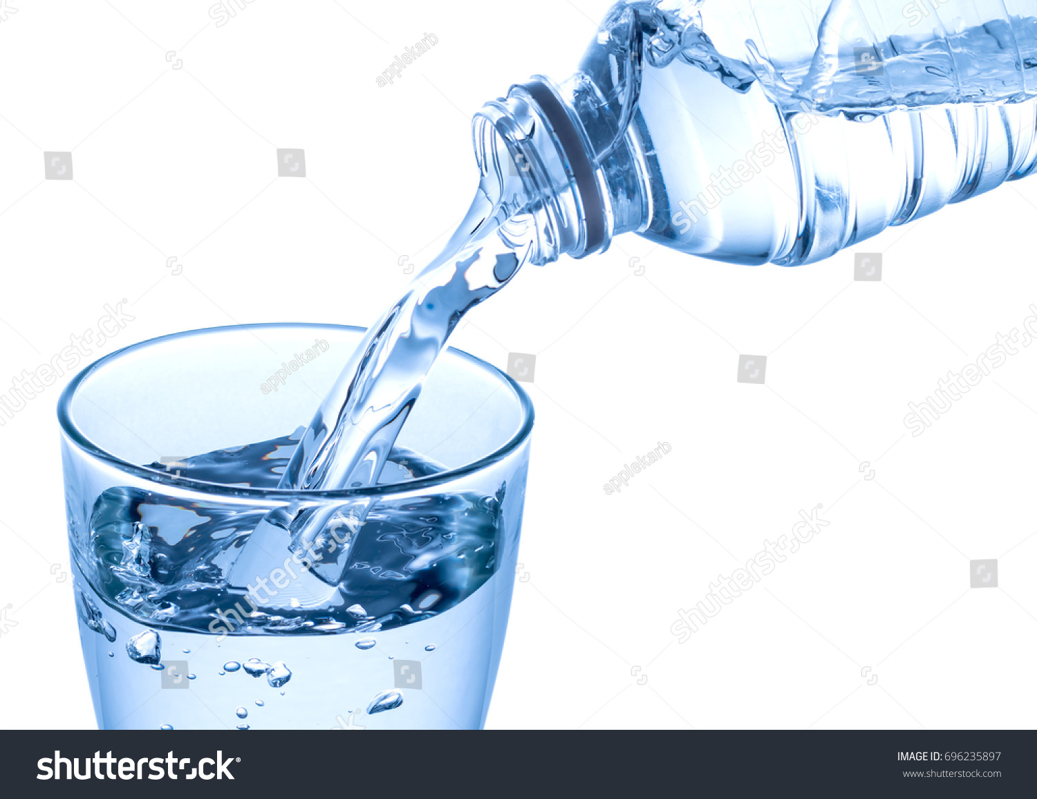 Pouring water on a glass isolated on white background. Clipping path #696235897
