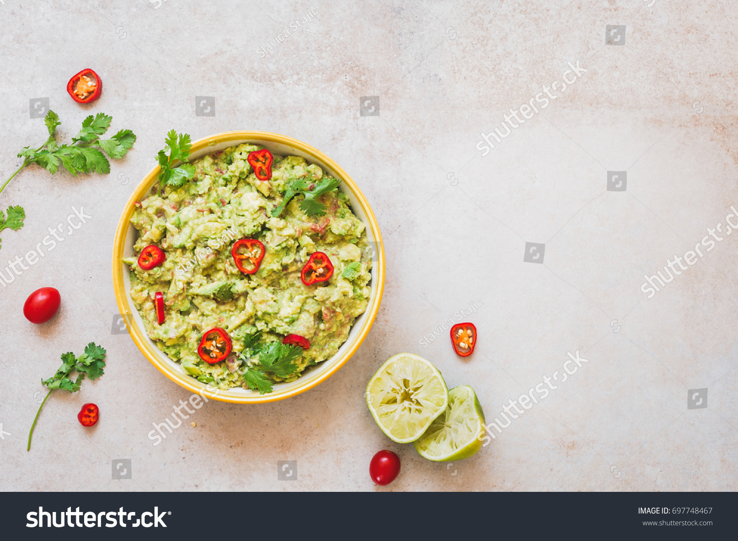 Fresh guacamole dip with ingredients on rustic stone background. Top view, lots of copy space #697748467