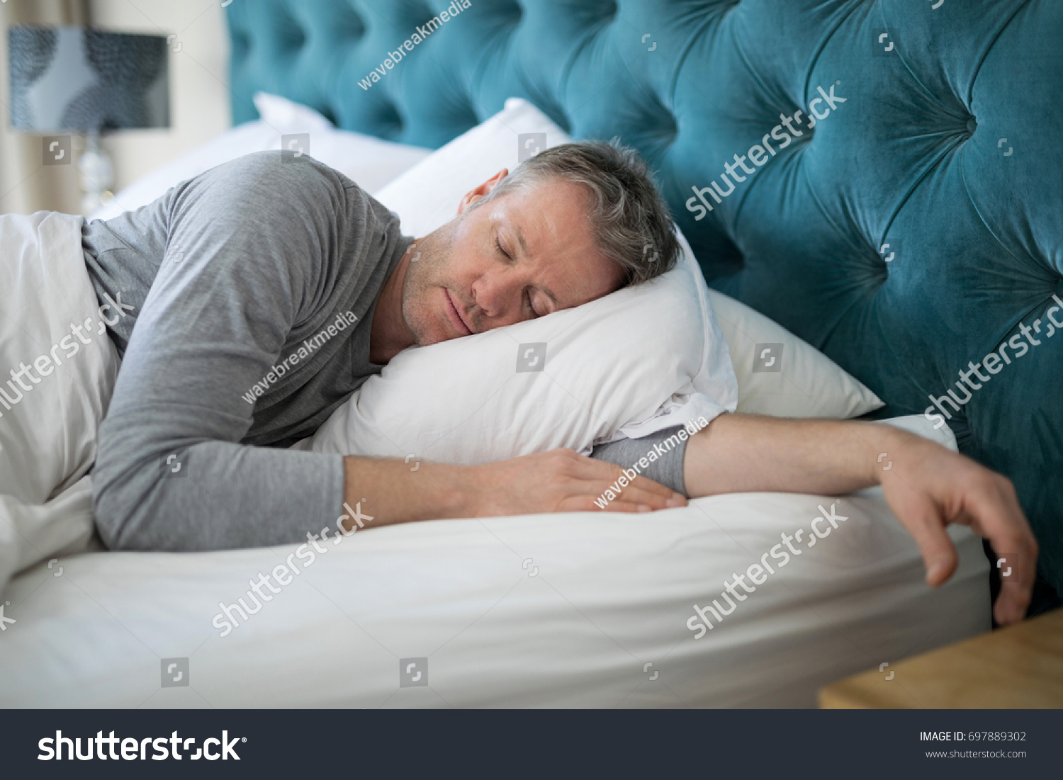 Man sleeping on bed in bedroom at home #697889302