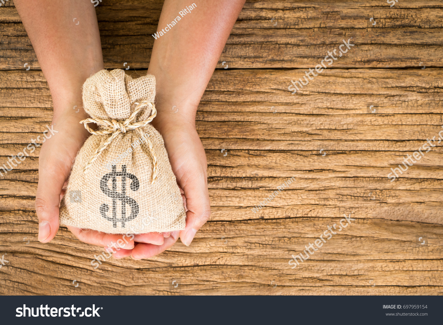 Women hold a money bag on the vintage wood background, a loan or saving money for future investment concept. #697959154