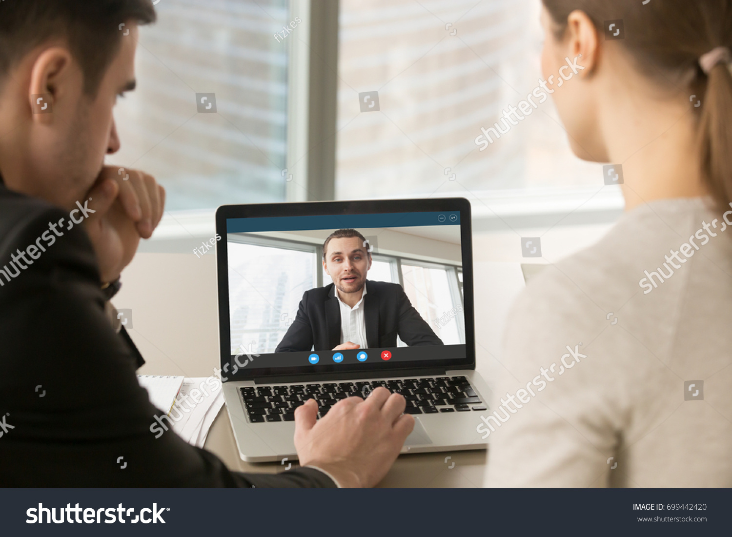 Employees participate virtual conference with boss running business remotely, businesspeople hold online meeting on laptop group chat, entrepreneurs making video call to partner, close up rear view #699442420