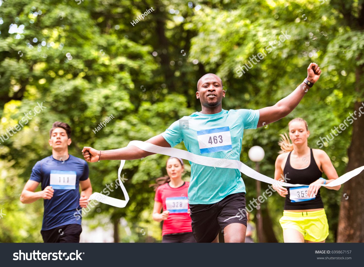 Young man running in the crowd crossing the finish line. #699867157