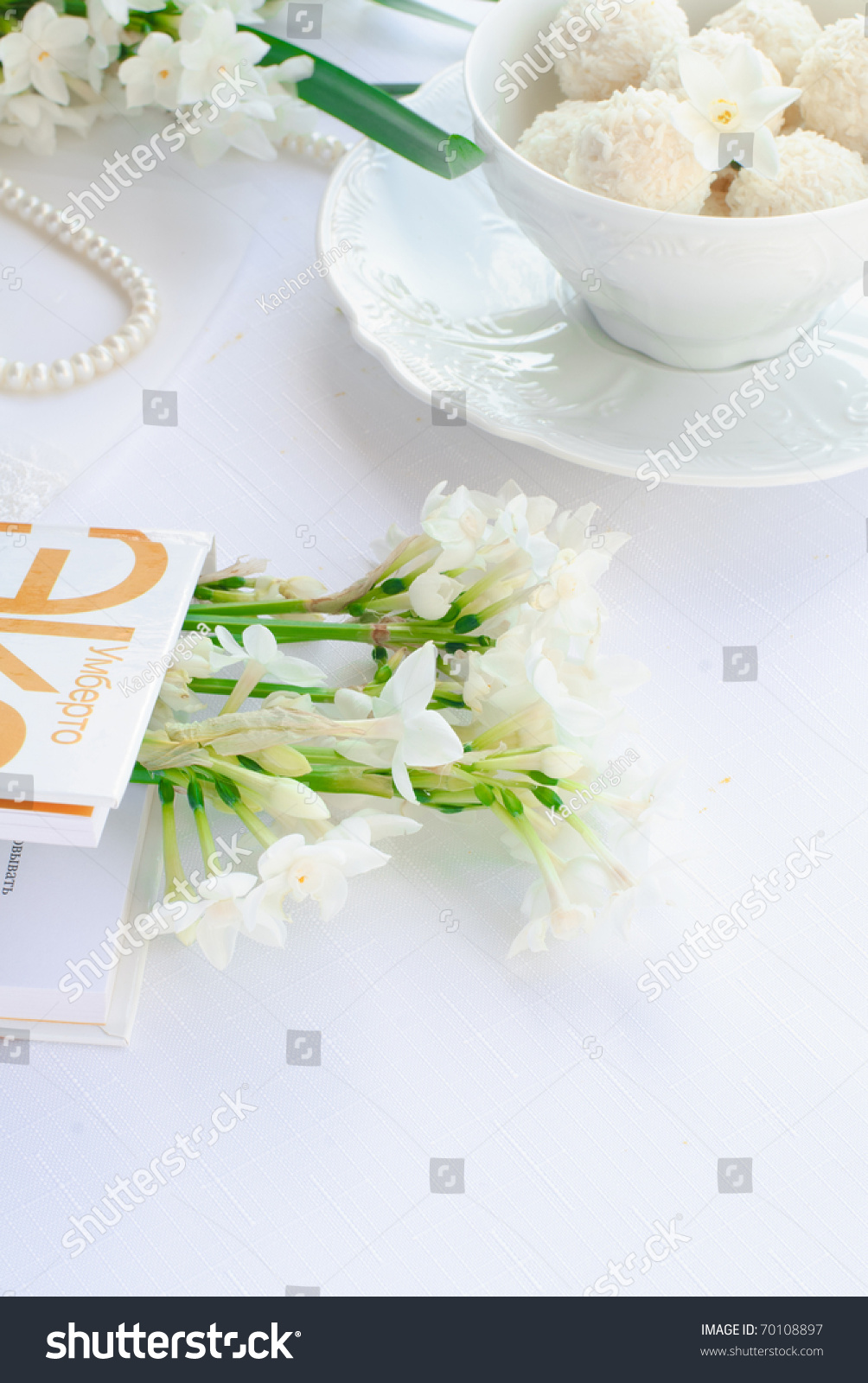 white narcissus, book, white cup with candies #70108897