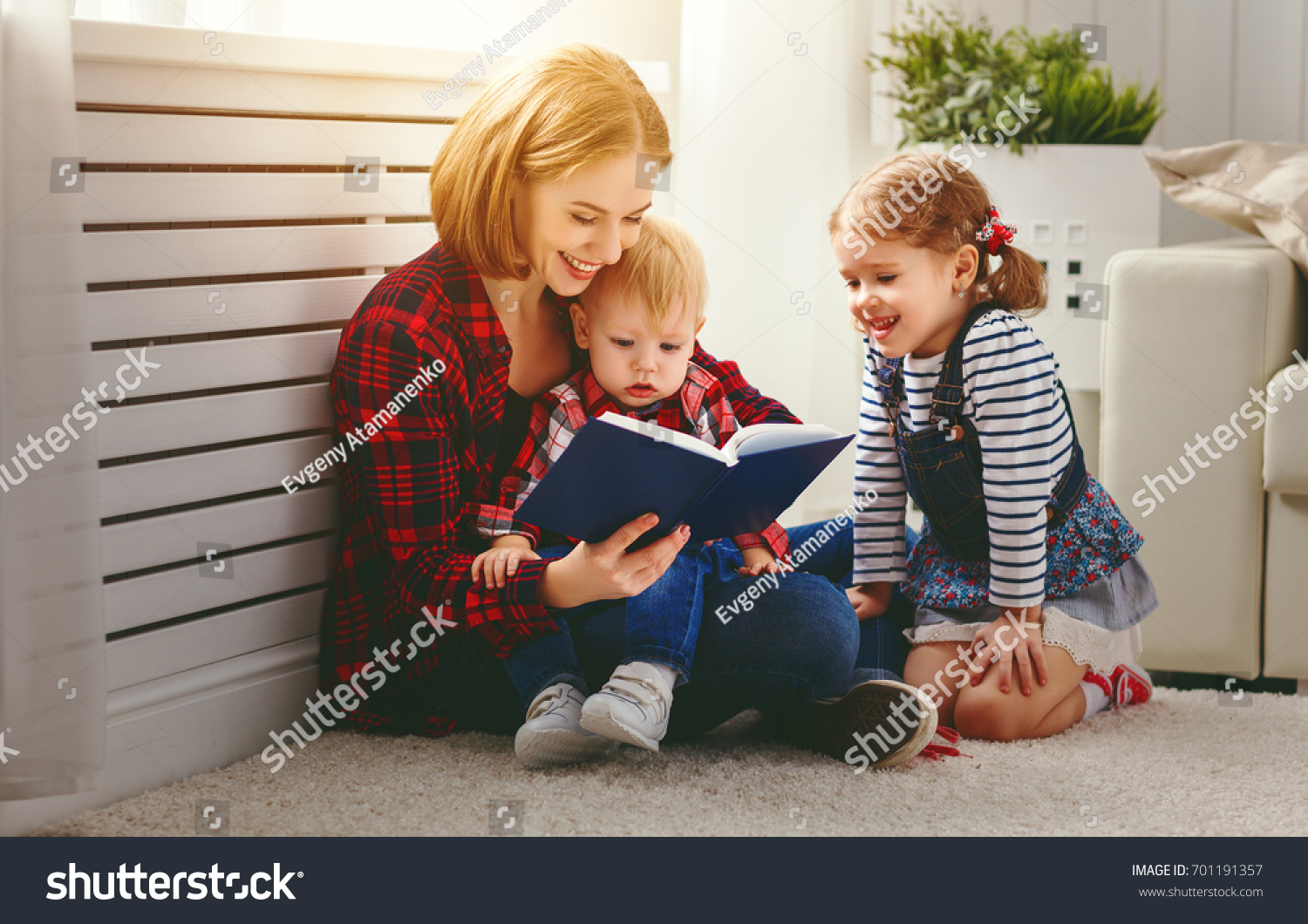 Mother reads book to children son and daughter
 #701191357