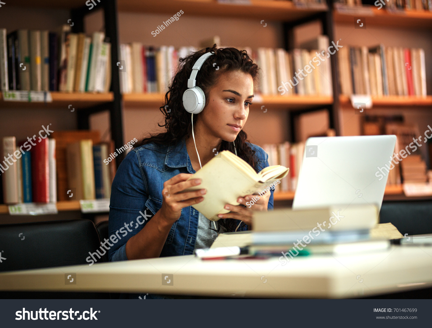 Young female student study in the school  library.She using laptop and learning online. #701467699