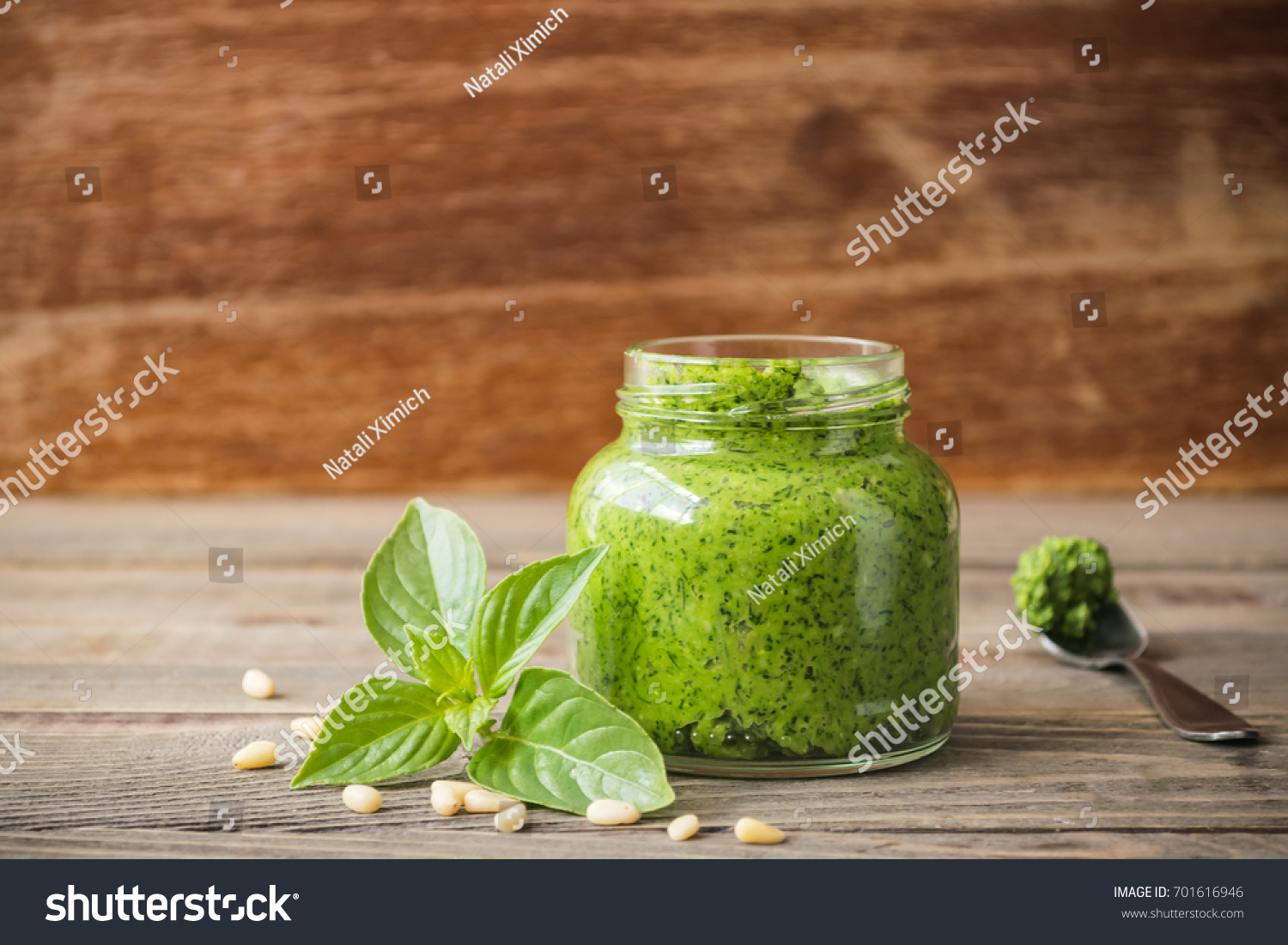 Homemade pesto sauce fresh Basil and nuts on wooden brown background. A copy of the places. Soft focus. The horizontal frame.Front view. #701616946
