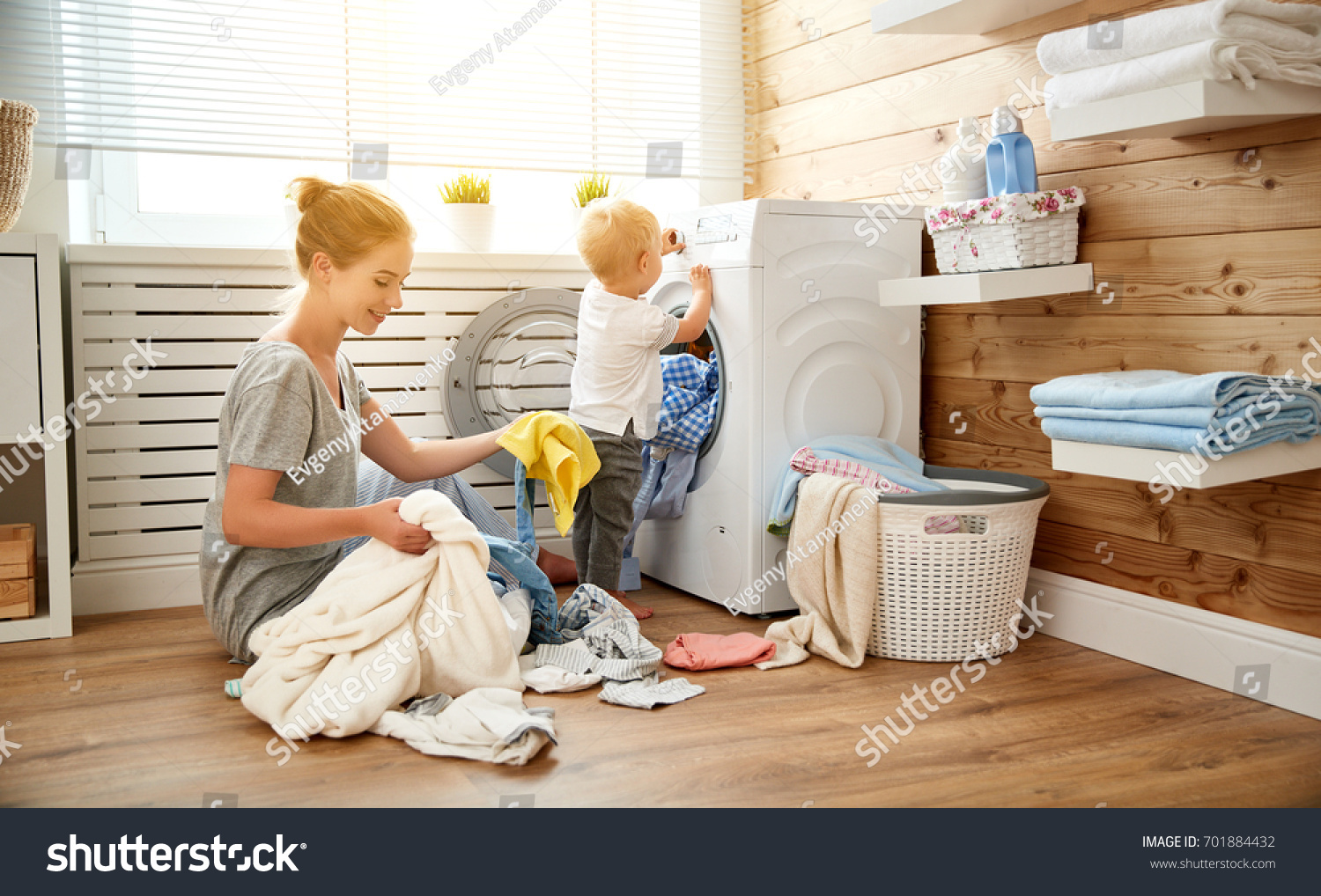 Happy family mother  housewife and children in the laundry load a washing machine
 #701884432